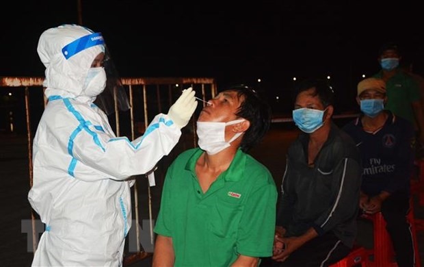 Nhân viên y tế lấy mẫu xét nghiệm cho người dân Cảng cá Thọ Quang. (Ảnh: Văn Dũng/TTXVN)