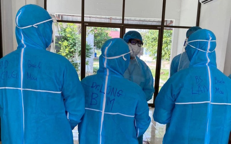 Ba bác sĩ và điều dưỡng của Bệnh viện Bạch Mai chuẩn bị vào hội chẩn bệnh nhân cấp cứu tại Bệnh viện Phonthong. Ảnh: Bộ Y tế