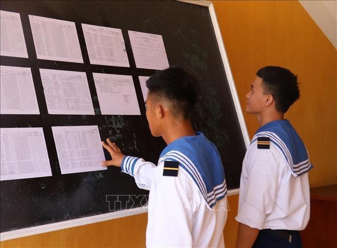 Hai chiến sỹ trẻ lần đầu tiên được đi bầu, theo dõi danh sách cử tri được niêm yết tại UBND xã Song Tử Tây (huyện Trường Sa, tỉnh Khánh Hòa). Ảnh: Sỹ Tuyên, Phan Sáu, Thắng Trung/TTXVN