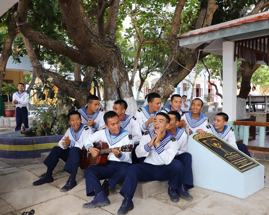 Chiến sỹ trẻ đảo Sơn Ca sinh hoạt văn nghệ dưới gốc cây mù u hơn 300 năm tuổi - được công nhận là cây di sản Việt Nam. (Ảnh: Sỹ Tuyên/TTXVN)