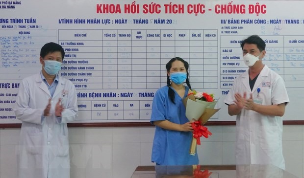Lãnh đạo Bệnh viện Đà Nẵng trao hoa chúc mừng bệnh nhân. (Ảnh: TTXVN)