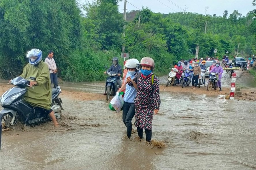 Giáo viên lội bộ qua điểm cầu tràn Km12 ở xã Thanh bị ngập nước sau cơn mưa ngày 25.5. Ảnh: CTV.