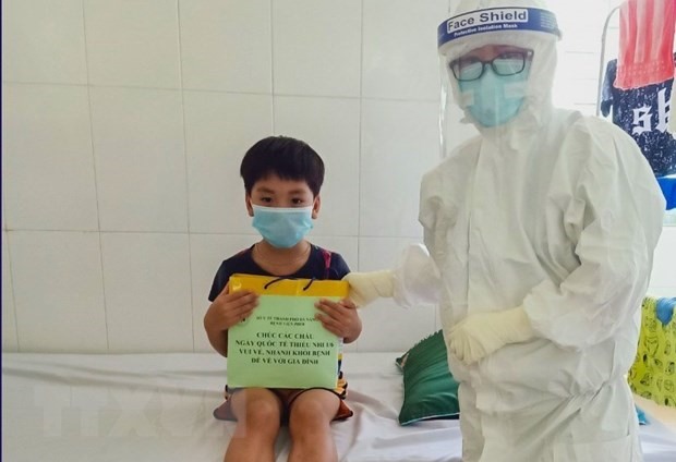 Nhân viên y tế Bệnh viện Phổi Đà Nẵng trong trang phục bảo hộ y tế đến tặng quà cho các em thiếu nhi mắc COVID-19 đang điều trị tại bệnh viện. (Ảnh: TTXVN phát)