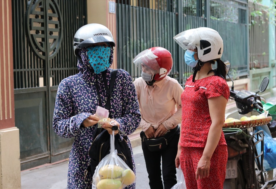 Chị Nguyễn Hồng Anh (ngoài cùng, bên trái), thường để riêng số tiền mặt cần dùng ra ngoài mỗi khi đi chợ. Ảnh: Lan Nhi