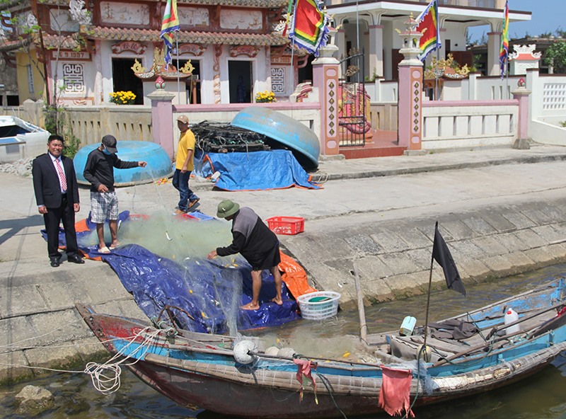 Ông Bùi Đình Chiến (thứ nhất, bên trái) hỏi thăm tình hình đánh bắt hải sản của ngư dân thị trấn Cửa Việt -Ảnh: M.Đ