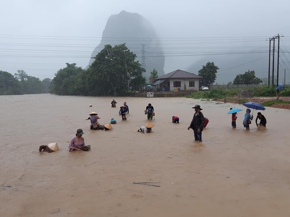 Nước lên, người dân tranh thủ đi vớt cá ở thị trấn Vang Vieng