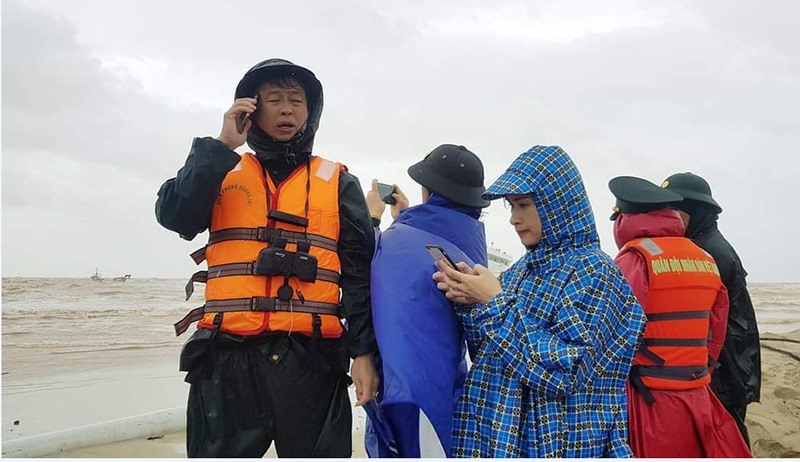 Phóng viên (mặc áo mưa kẻ ca rô) tác nghiệp tại sự kiện cứu hộ tàu Vietship 01 mắc cạn trên biển Cửa Việt tháng 10/2020 - Ảnh: BẢO BÌNH