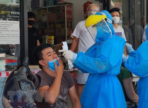 Nhân viên y tế lấy mẫu xét nghiệm của người dân quanh khu vực có ca mắc COVID-19 tại đường Lê Duẩn. (Ảnh: Văn Dũng /TXVN)