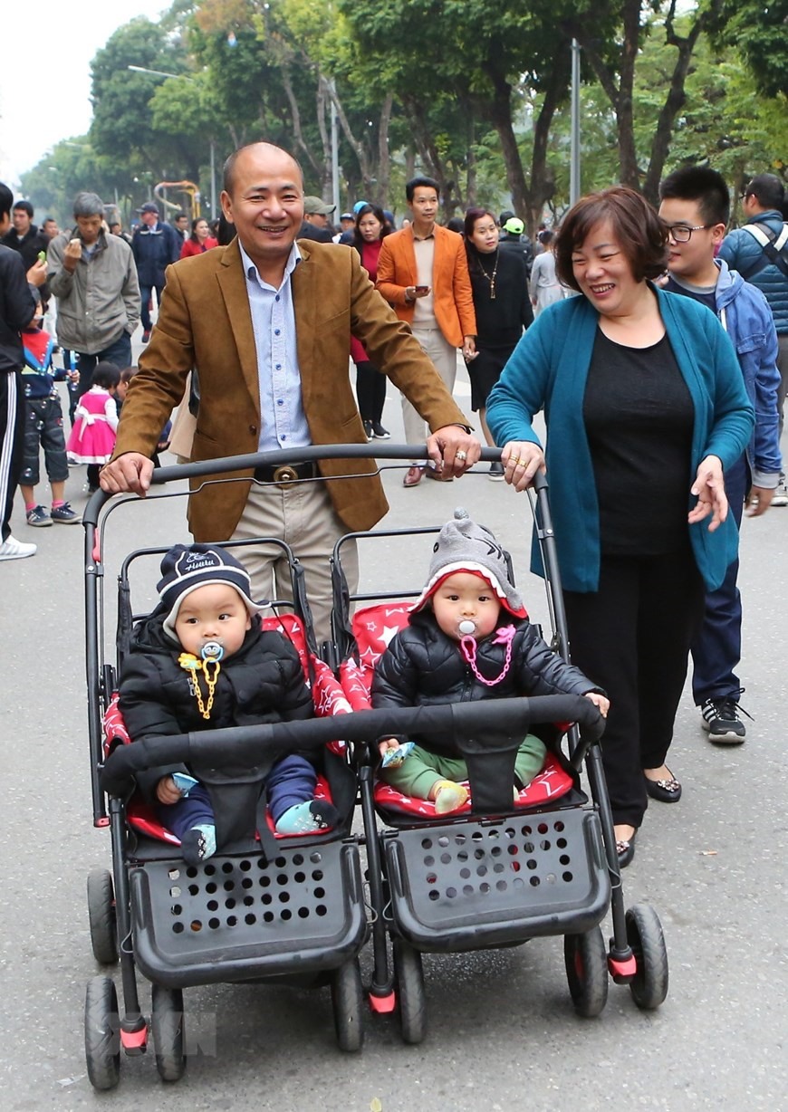 Hình ảnh ông bà mẫu mực, gia đình hạnh phúc (ảnh chụp tại phố đi bộ hồ Hoàn Kiếm). (Ảnh: Thành Đạt/TTXVN)