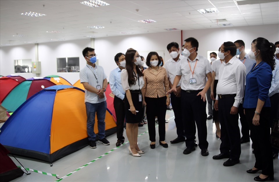 Phó Thủ tướng Lê Văn Thành (thứ 2 bên phải) nghe lãnh đạo Công ty Goertek báo cáo về mô hình “vừa sản xuất, vừa chống dịch“. Ảnh: Đức Tuân