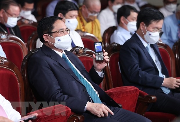 Thủ tướng Phạm Minh Chính và các đại biểu nhắn tin ủng hộ Quỹ vaccine. (Ảnh: Dương Giang/TTXVN)