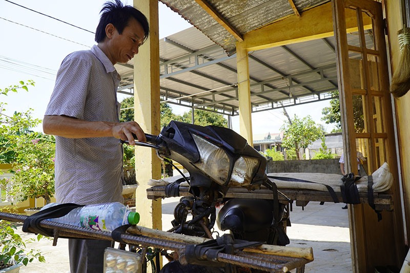 Anh Võ Hoàng ở xã Tân Long, huyện Hướng Hóa kiểm tra lại chiếc xe máy chở chuối, 2 năm qua không mấy khi dùng -Ảnh: N.P
