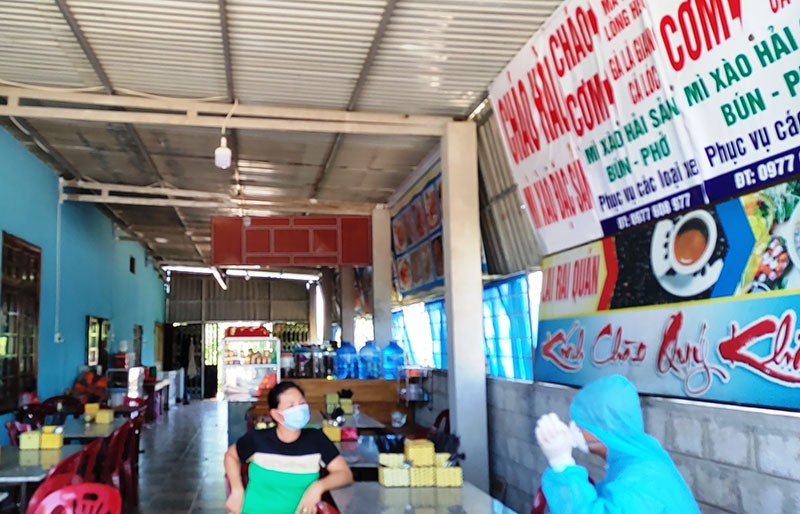 Thành viên Đội đáp ứng nhanh của Trung tâm KSBT tỉnh Quảng Trị khai thác thông tin dịch tễ tại quán ăn có người mắc COVID-19 -Ảnh: NVCC