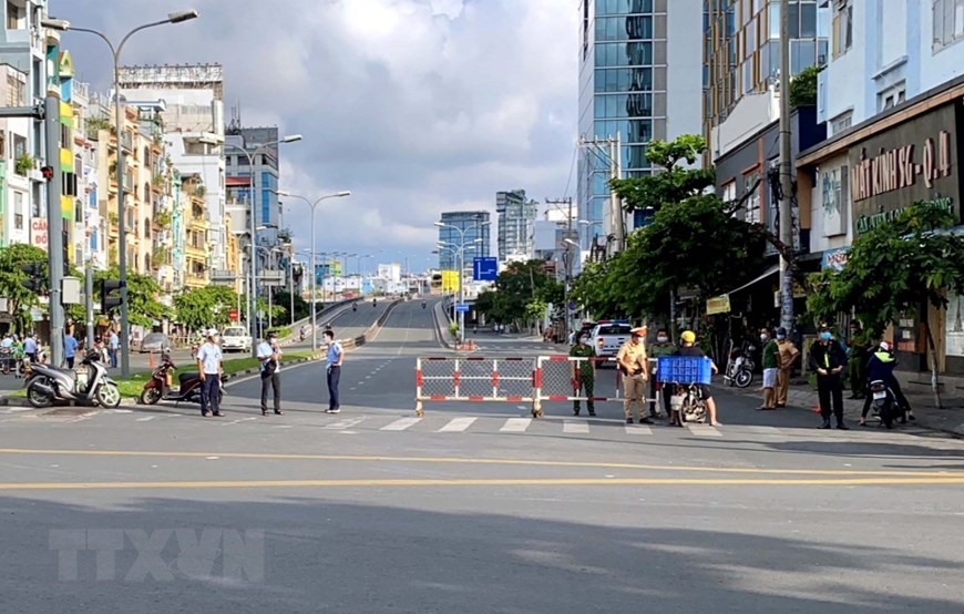 Lực lượng công an và dân quân phường 11, quận Bình Thạnh vẫn trực kiểm soát tại chốt ngã tư đường Lê Quang Định-Phan Văn Đậu (quận Bình Thạnh). (Ảnh: Thanh Vũ/TTXVN)