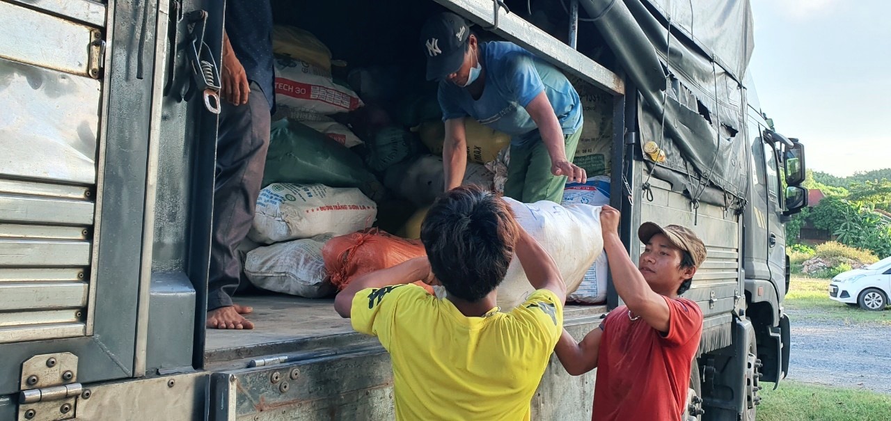 Người dân huyện Đakrông hỗ trợ bốc vác lương thực, thực phẩm lên xe - Ảnh: T.L