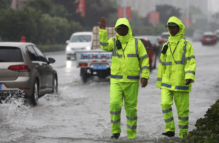 Cảnh sát giao thông điều khiển phương tiện trên tuyến đường bị ngập lụt do mưa lớn kéo dài tại huyện Vũ Trắc, tỉnh Hà Nam, Trung Quốc ngày 20/7/2021. (Ảnh: THX/TTXVN)