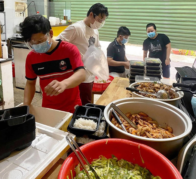 Các thành viên quán ăn Cà Mèn chuẩn bị cơm cho người nghèo - Ảnh:NVCC