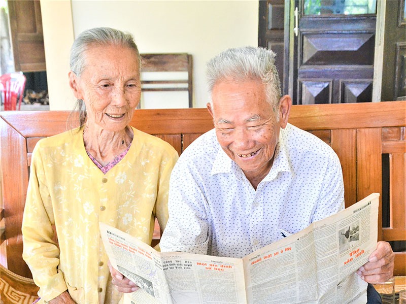 Thầy Lê Văn Khuyến cùng vợ đọc lại bài báo viết về Kế hoạch 8 mà thầy từng tham gia - Ảnh: A.P