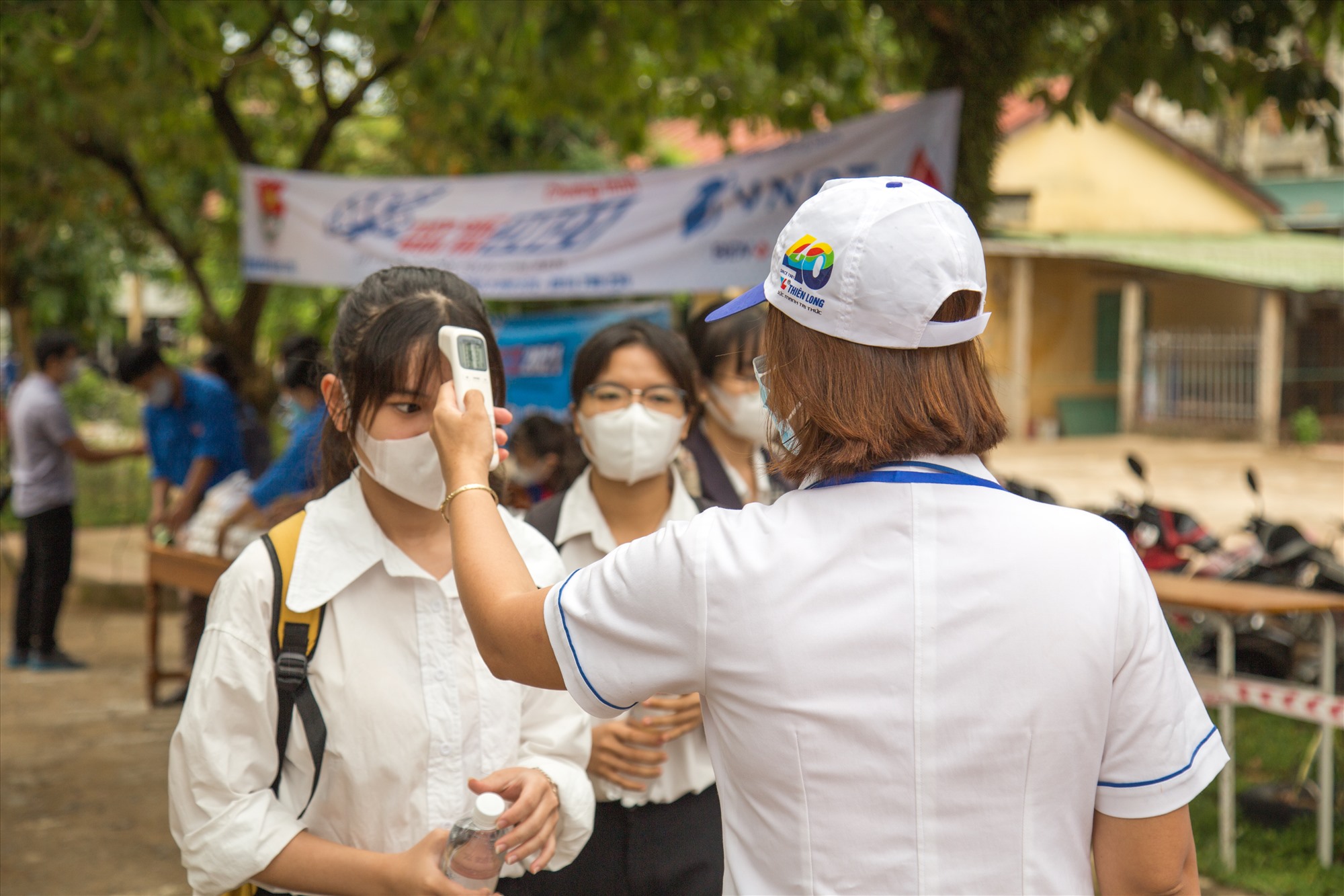 Kiểm tra thân nhiệt thí sinh trước khi vào phòng thi - Ảnh: LÊ TRƯỜNG