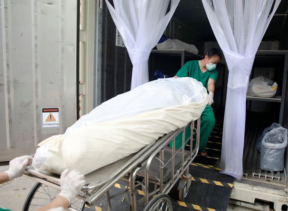 Các nhân viên y tế chuyển một thi thể vào container đông lạnh ở Pathum Thani, Thái Lan ngày 31/7. Ảnh: Reuters