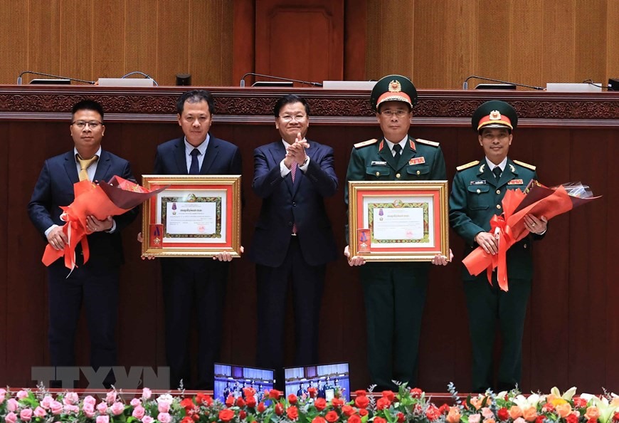 Tổng Bí thư, Chủ tịch nước Lào Thongloun Sisoulith trao Huân chương Tự do hạng Nhì cho Ban quản lý dự án, Bộ Xây dựng và Binh đoàn 11, Bộ Quốc phòng Việt Nam. (Ảnh: Thống Nhất/TTXVN).