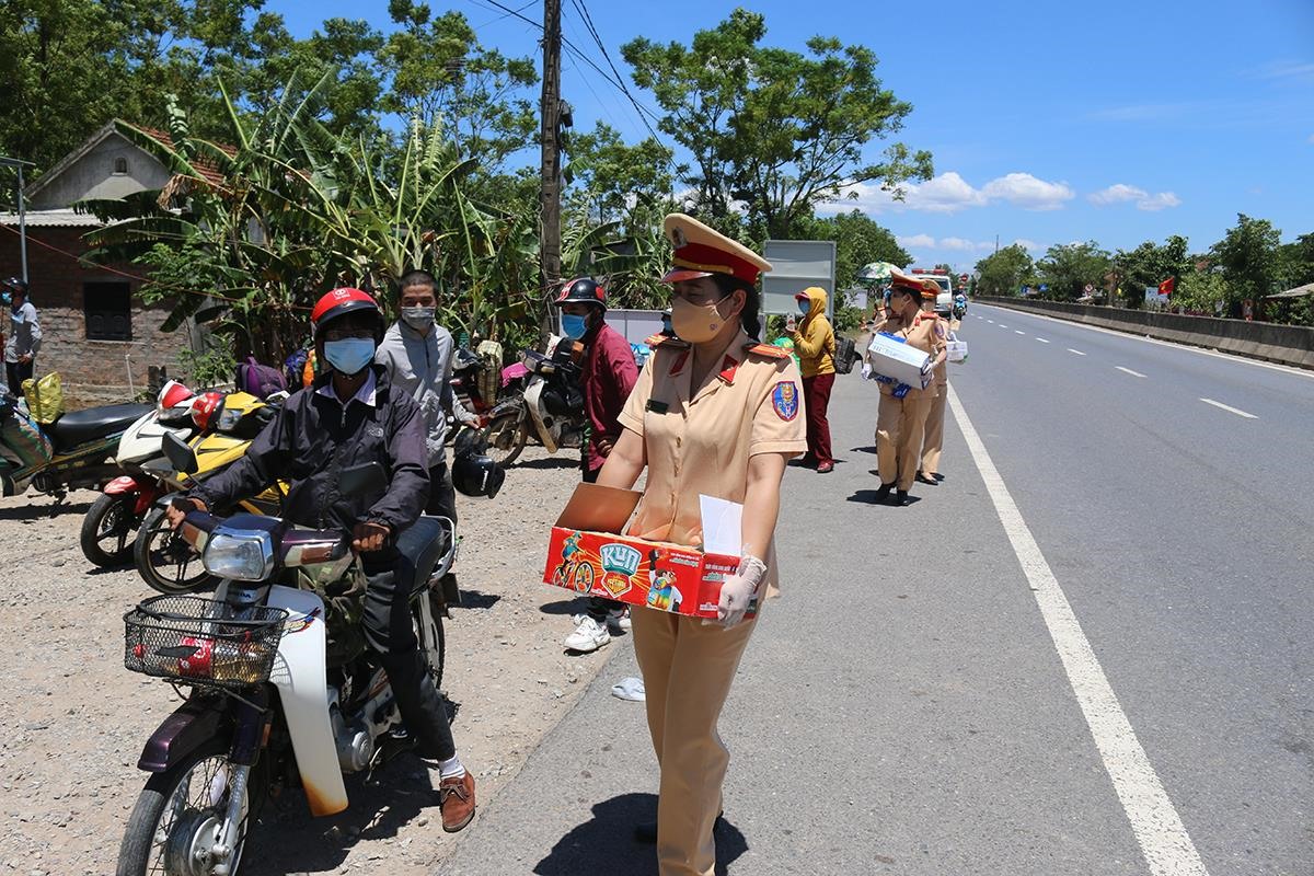 Trung tá Lê Thị Hoài Hương phát sữa cho người dân trở về từ TP. Hồ Chí Minh bằng xe máy - Ảnh: T.N