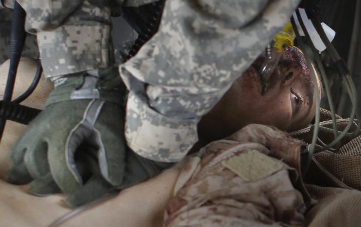 Một thành viên thuộc đội y tế của quân đội Mỹ sơ cứu cho một lính thủy đánh bộ bị thương nặng trong vụ nổ do thiết bị nổ tự chế gần thị trấn Marjah, tỉnh Helmand, Afghanistan, ngày 22/8/2010.