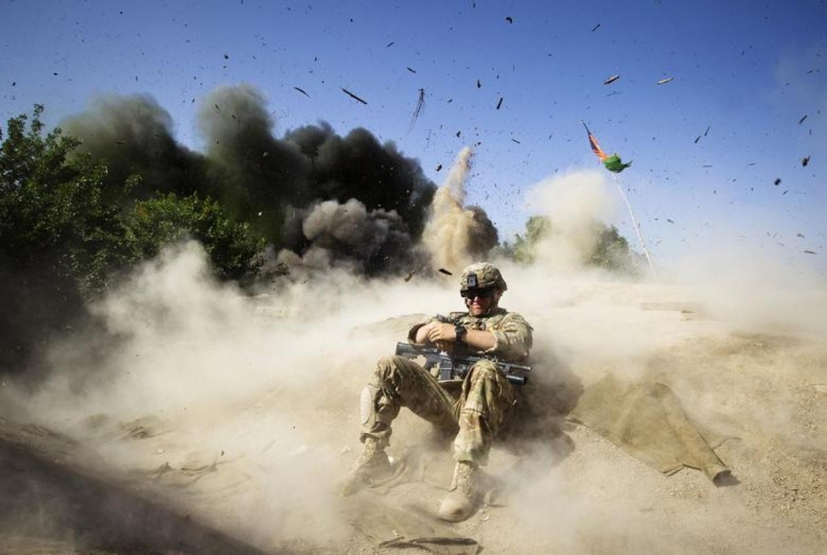 Binh sĩ Jake Beaudoin thuộc Lục quân Mỹ ẩn nấp trong một vụ nổ có kiểm soát nhằm dọn sạch một khu vực để thiết lập trạm kiểm soát ở huyện Zahri, tỉnh Kandahar, miền Nam Afghanistan, ngày 31/5/2012.