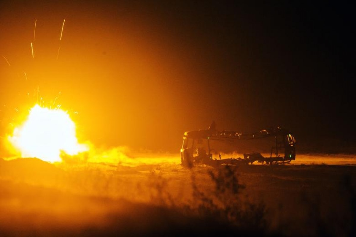 Một tên lửa do binh sĩ Mỹ bắn phát nổ bên cạnh một chiếc xe buýt bị hư hỏng tại căn cứ điều hành Gamberi ở tỉnh Laghman, Afghanistan, ngày 31/12/2014.