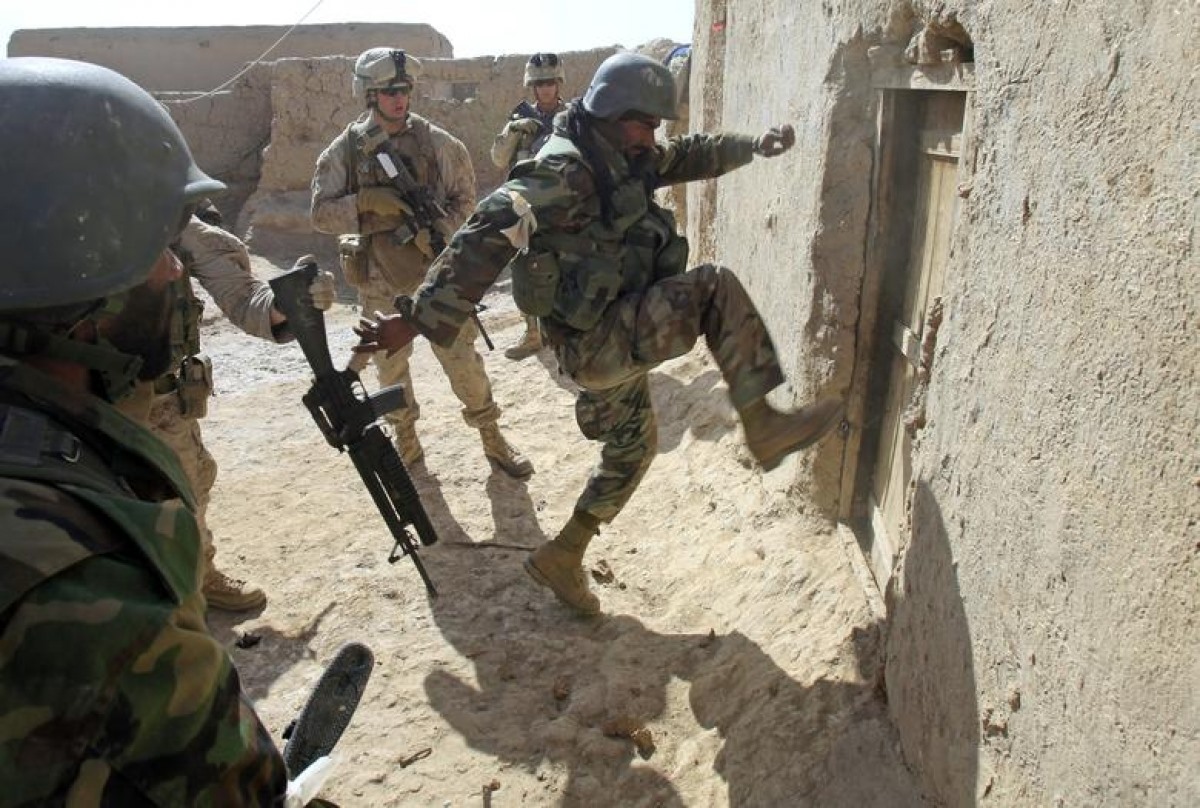 Một binh sĩ Afghanistan cố gắng phá cửa khi Thủy quân lục chiến Mỹ của đại đội Bravo đang theo dõi trong một chiến dịch tìm kiếm vũ khí tại thị trấn Marjah, huyện Nad Ali, tỉnh Helmand, Afghanistan vào ngày 17/2/2010.