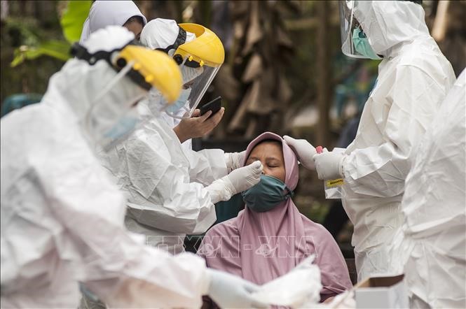 Nhân viên y tế lấy mẫu xét nghiệm COVID-19 cho người dân tại Yogyakarta, Indonesia, ngày 4/8/2021. Ảnh: THX/TTXVN