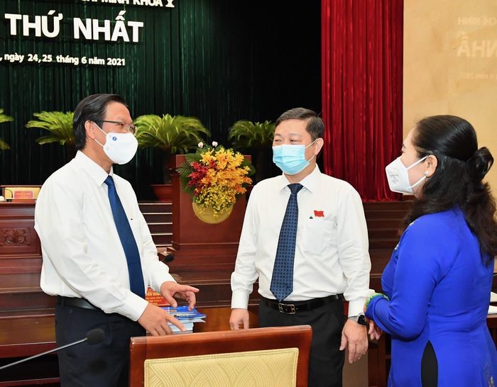 Ông Phan Văn Mãi (bên trái) trao đổi với các đại biểu tại phiên khai mạc kỳ họp thứ nhất HĐND TPHCM khóa X, nhiệm kỳ 2021 - 2026