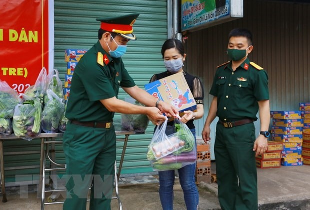 Lực lượng bộ đội thuộc Sư đoàn 302-Quân khu 7 gửi tặng nhu yếu phẩm cho người dân đang thực hiện cách ly tại nhà ở phường Xuân Thanh, Cẩm Mỹ, Đồng Nai. (Ảnh: Lê Xuân/TTXVN)