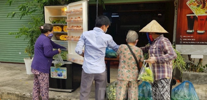 Bà con cho - nhận thực phẩm trong “Tủ lạnh cộng đồng” tại Quận Bình Thạnh, TP.HCM. Ảnh: Kim Tuyết