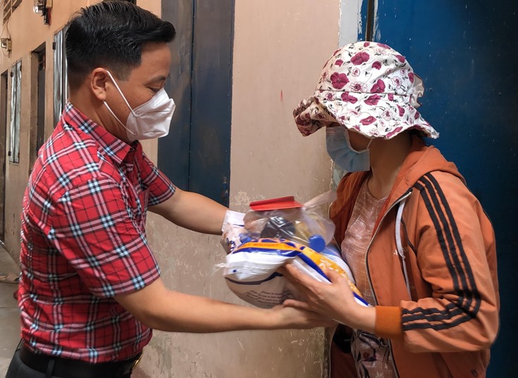 Ông Nguyễn Văn Dưỡng, Chủ tịch BCH Hội đồng hương huyện Quảng Ninh tại TP.HCM, trao gạo và cá khô cho bà con đồng hương gặp khó khăn do dịch bệnh. Ảnh: AN NHIÊN