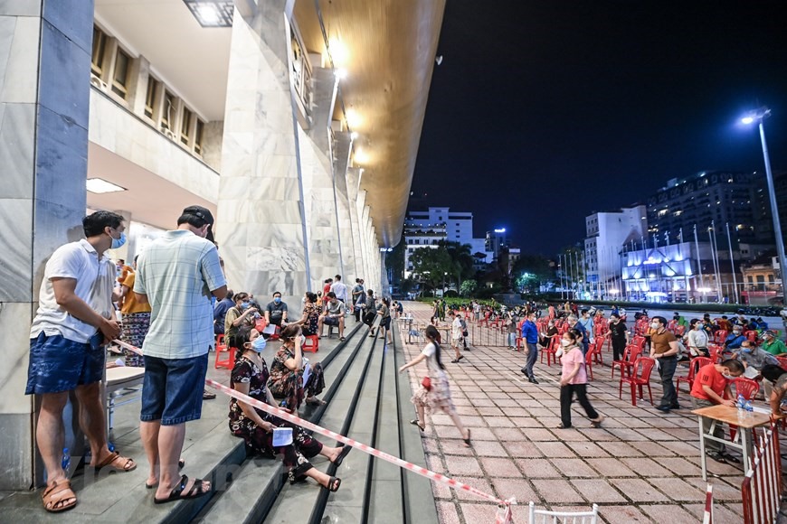 Đây là ngày đầu tiên quận tổ chức tiêm thêm vào ban đêm nhằm đáp ứng yêu cầu sớm phủ vaccine phòng COVID-19 cho người dân. (Ảnh: PV/Vietnam+)