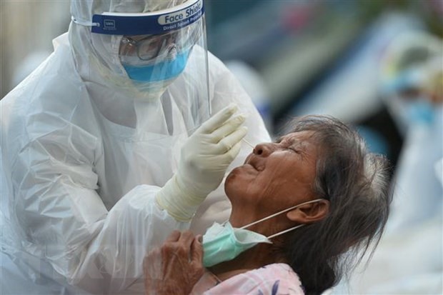 Nhân viên y tế lấy mẫu dịch xét nghiệm COVID-19 cho người dân tại tỉnh Samut Sakhon, Thái Lan. (Ảnh: THX/TTXVN)