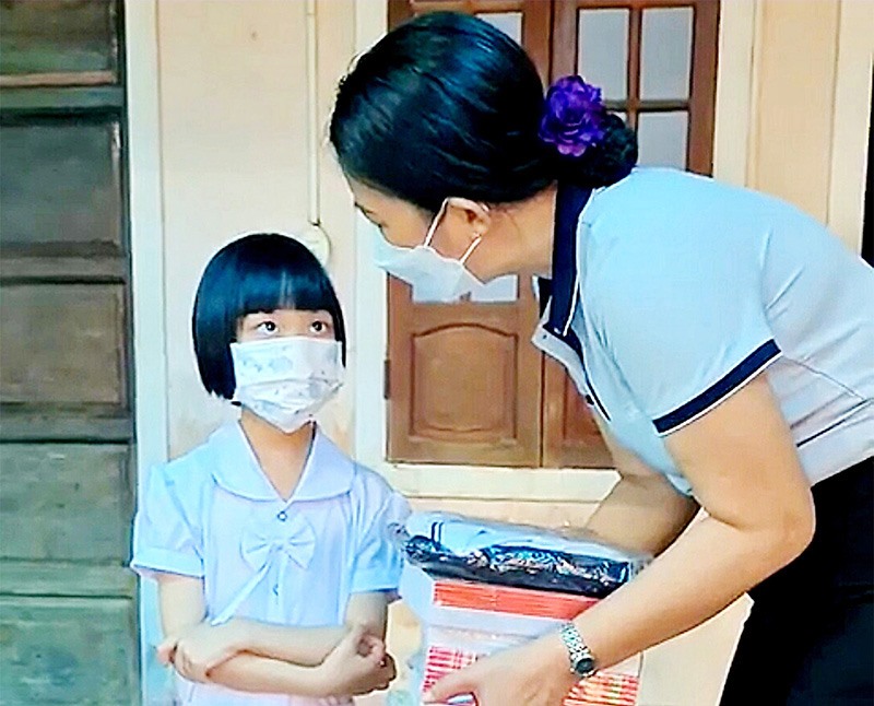 Hiệu trưởng Trường Tiểu học Nguyễn Trãi, thị xã Quảng Trị tặng quà động viên học sinh về quê tránh dịch được nhà trường tiếp nhận -Ảnh: TÚ LINH