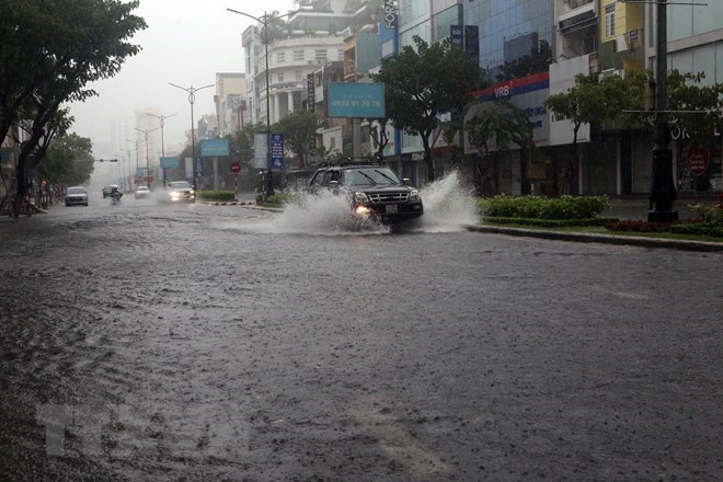 Dân quân phường Nam Dương (quận Hải Châu) tiến hành thông cửa thu nước trên các tuyến đường để chống ngập. (Ảnh: Trần Lê Lâm/TTXVN)