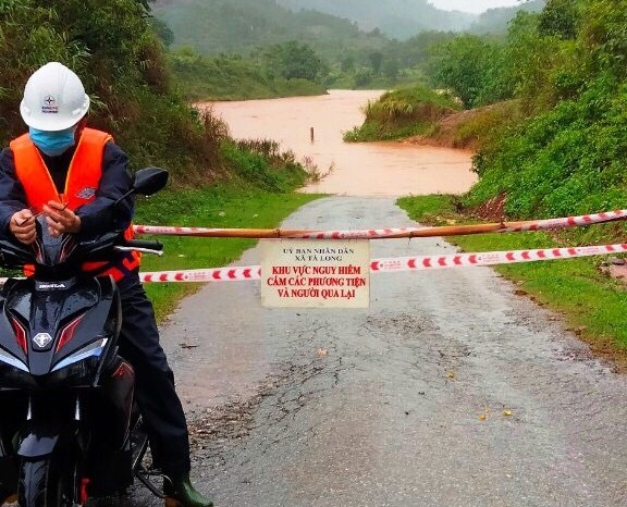 Cắm biển cảnh báo nguy hiểm do nước lũ lên nhanh tại xã Tà Long - Ảnh: L.T