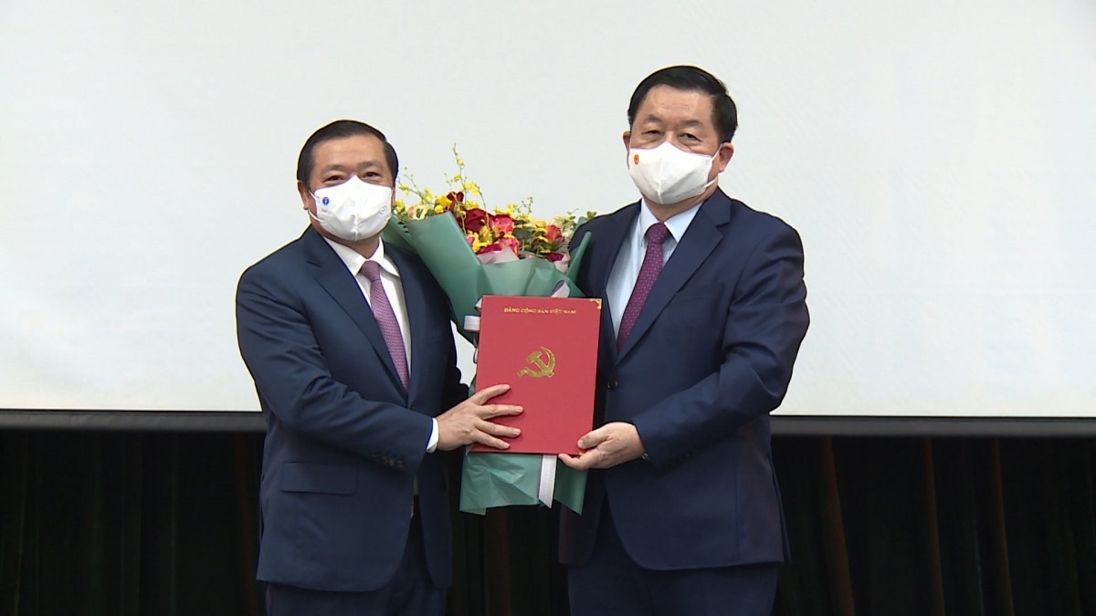 Ông Nguyễn Trọng Nghĩa trao quyết định và tặng hoa chúc mừng ông Lại Xuân Môn.
