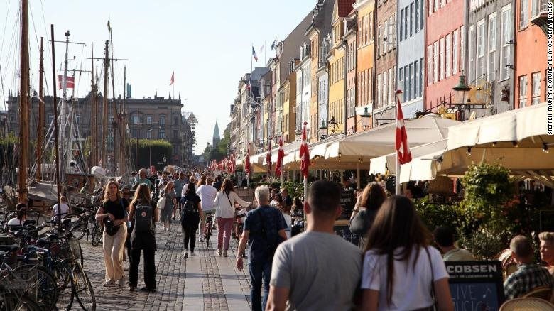 Người dân đi dọc Nyhavn, một bến cảng đầy màu sắc nổi tiếng với du khách, ở thủ đô Copenhagen của Đan Mạch vào ngày 3/9. Ảnh: CNN