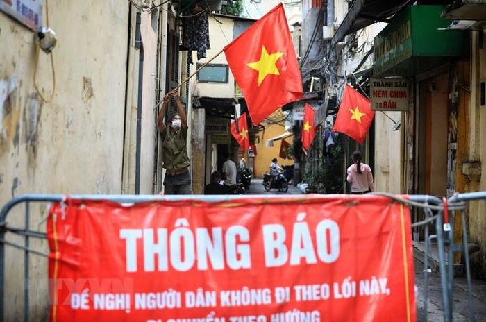 Từ sáng sớm ngày 30/8, người dân ngõ Tạm Thương, quận Hoàn Kiếm đã rục rịch treo cờ Tổ quốc chào mừng 76 năm Quốc khánh 2/9. (Ảnh: Thành Đạt/TTXVN)