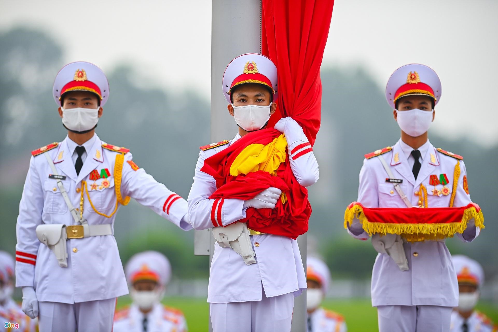 3 chiến sĩ của đội hồng kỳ nghiêm trang bước lên bục để chuẩn bị thực hiện các nghi thức chính. Lúc 5h59 phút, chiến sĩ mang Quốc kỳ treo lên cột cờ.