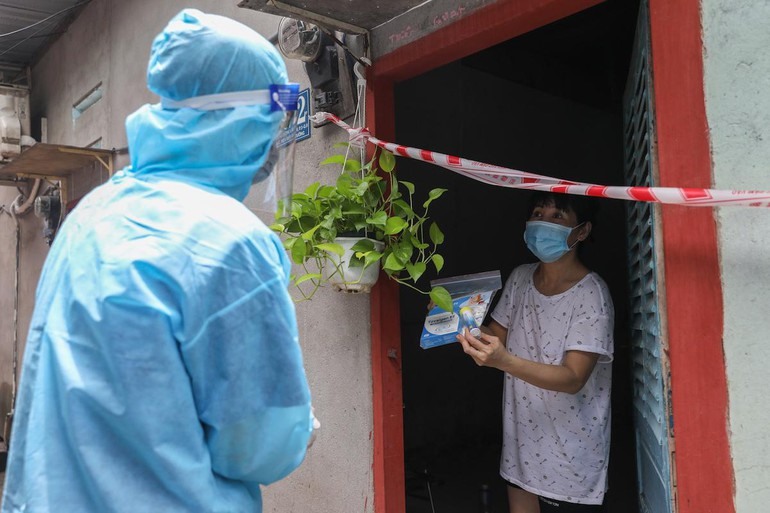 Nhân viên y tế phường 3, quận 8 đến thăm khám, tặng thuốc cho người mắc Covid-19 đang điều trị tại nhà, ngày 29-8 - Ảnh: Quỳnh Trần