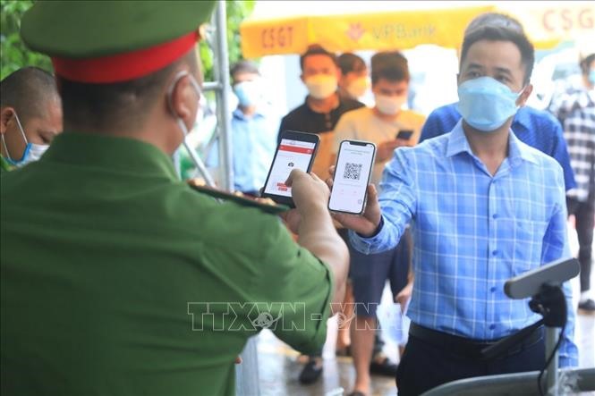 Lực lượng công an kiểm tra mã QR của người dân vào Hà Nội tại chốt kiểm soát dịch cầu Phù Đổng. Ảnh: Tuấn Anh/TTXVN