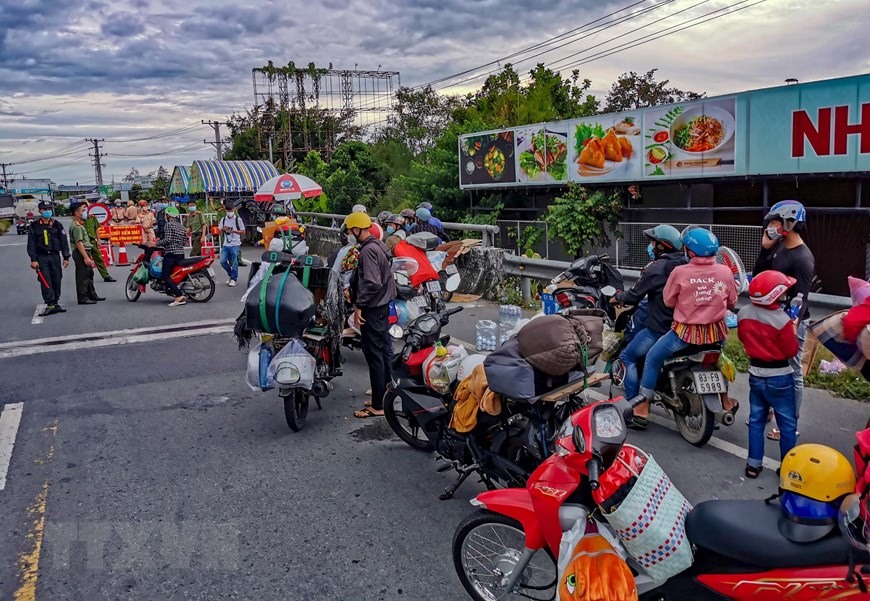 Người dân đi xe máy về quê bị kẹt giữa cầu số 10 giáp ranh giữa Cần Thơ và Hậu Giang, chiều 25/9. (Ảnh: Thanh Liêm/TTXVN)