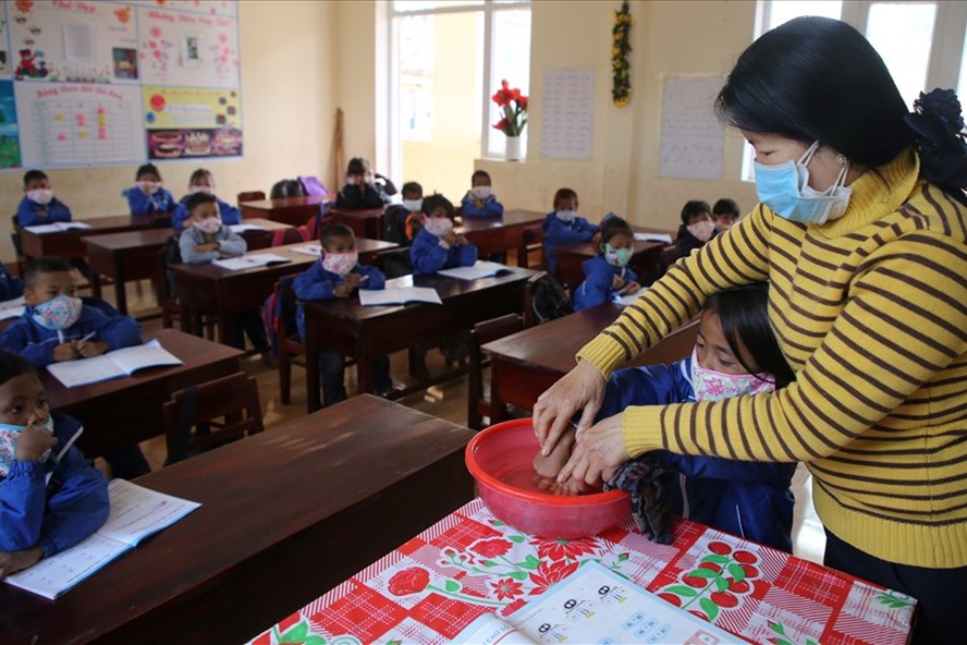 Giáo viên miền núi tỉnh Quảng Trị hướng dẫn cho các em học sinh người đồng bào thiểu số rửa tay phòng COVID-19 trong năm học 2020-2021. Ảnh: Hưng Thơ.