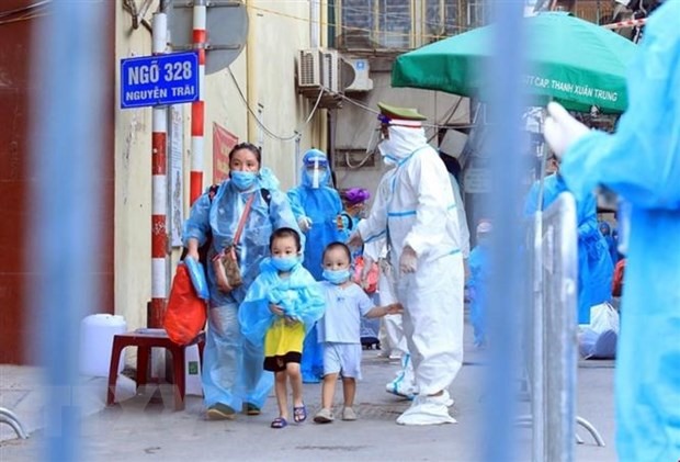Trẻ em ở Thanh Xuân Trung theo gia đình di chuyển đến khu cách ly. (Ảnh: Tuấn Anh/TTXVN)