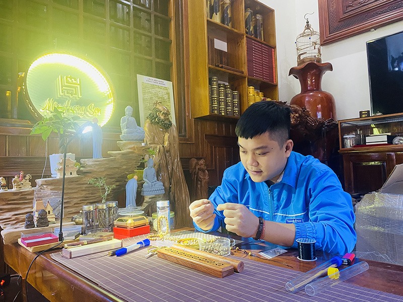 Anh Nguyễn Hồng Sơn miệt mài với những sản phẩm từ trầm hương - Ảnh: T.P